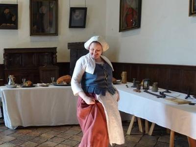 Person dressed up in historic clothing dancing at Strangers' Hall